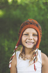 Happy girl wearing knit hat in summer - OMIF00066