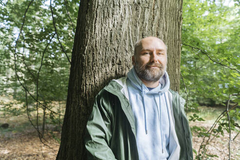 Bärtiger Mann vor einem Baum stehend - KMKF01746