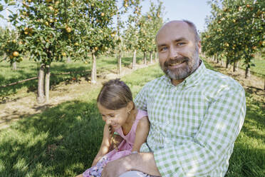 Vater und Tochter genießen das Wochenende auf der Apfelplantage - KMKF01766