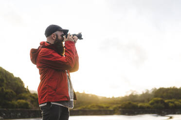 Male tourist photographing through camera - AFVF09224