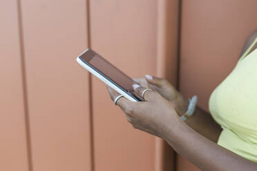 Frau benutzt Smartphone an der Wand - JRVF01808