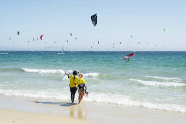 Kiteboard-Lehrerin gibt einer Frau am Strand Unterricht - PGF00803