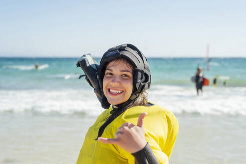 Lächelnde Frau gestikuliert beim Training am Strand - PGF00808
