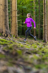 Weibliche Athletin läuft im Wald - STSF03038