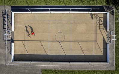 Young male and female athlete playing basketball during sunny day - STSF03044