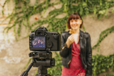 Woman recording video at park - MGRF00499