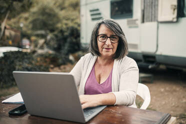 Camping Frau mit Laptop sitzend am Tisch - GRCF00874