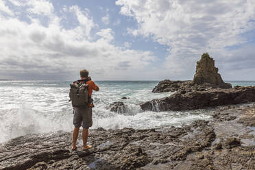 Male tourist photographing Cathedral Rocks at Jones Beach, Australia - FOF12190