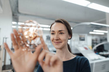 Female design professional touching 3D drone in workshop - KNSF08993