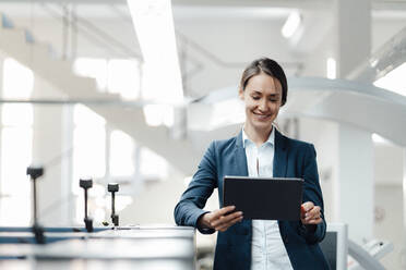 Female business professional using digital tablet in industry - KNSF08999