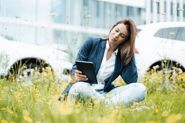 Freiberuflerin benutzt digitales Tablet im Park - GUSF06472