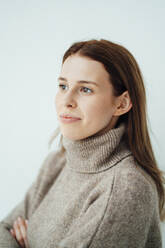 Woman with brown long hair by white background - GUSF06508