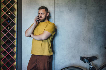 Geschäftsmann, der auf dem Fahrrad mit seinem Handy telefoniert - VPIF04952