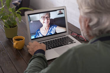 Älterer Mann nimmt an einem Videoanruf über einen Laptop zu Hause teil - SIPF02386