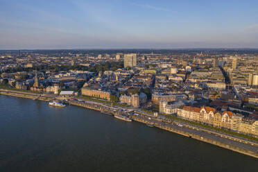 Germany, North Rhine-Westphalia, Dusseldorf, Aerial view of riverside city at dusk - TAMF03248