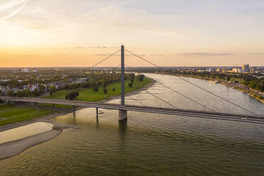 Germany, North Rhine-Westphalia, Dusseldorf, Aerial view of Oberkasseler Bridge at sunset - TAMF03254