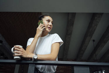 Weibliche Fachkraft, die im Büro mit einem Mobiltelefon spricht - VPIF05021