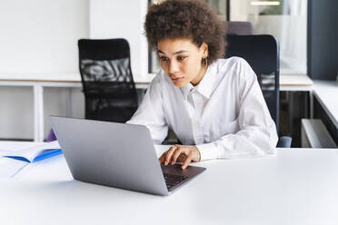 Junge Berufstätige mit Laptop am Schreibtisch im Büro - OIPF01130