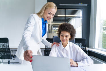 Weibliche Geschäftsleute teilen sich einen Laptop am Arbeitsplatz - OIPF01182