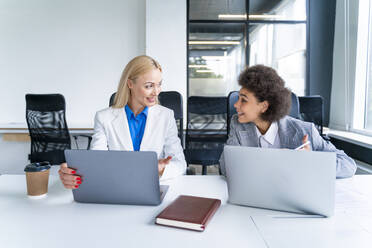 Businesswomen with laptop having discussion in office - OIPF01186