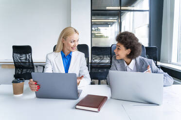 Geschäftsfrauen mit Laptop bei einer Diskussion im Büro - OIPF01186