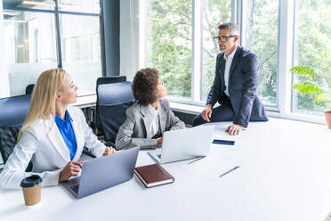 Male and female business professionals discussing in meeting at office - OIPF01193