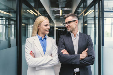 Smiling male and female business professionals looking at each other in office - OIPF01250