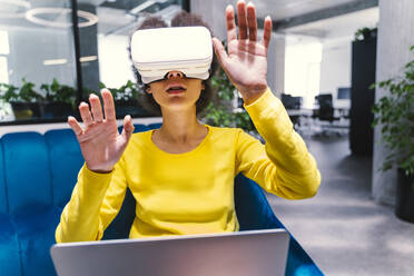 Geschäftsfrau mit Virtual-Reality-Headset in der Büro-Lobby - OIPF01275