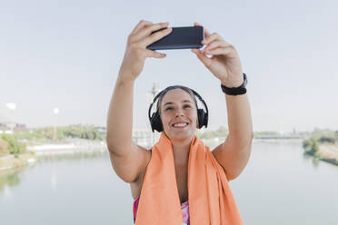 Junge Sportlerin macht Selfie mit ihrem Smartphone - JRVF01870