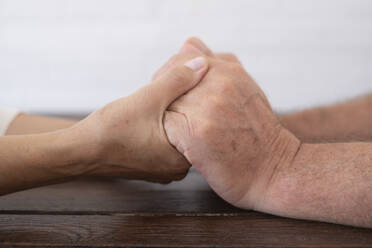 Senior couple holding hands on table - SIPF02391