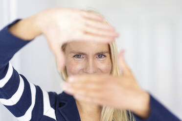 Woman making finger frame at home - WPEF05308