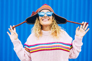 Cheerful mature woman wearing knit hat and sunglasses - SIPF02404