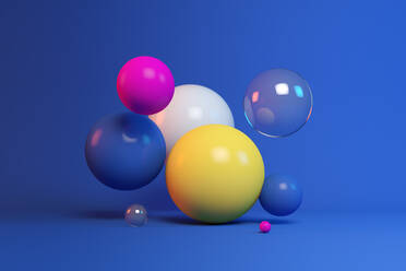 Three dimensional render of colorful spheres floating against blue background - JPSF00246