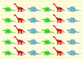 Muster aus grünen, roten und blauen Dinosaurierfiguren aus Kunststoff, flach auf gelbem Hintergrund - FLMF00674