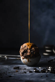 Studio shot of caramel pouring on scoop of chocolate ice cream - FLMF00676