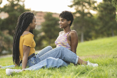 Lesbische Frauen, die sich im Sitzen im Gras verlieben - JCCMF03921