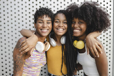 Cheerful woman with arms around female friends - JCCMF03933