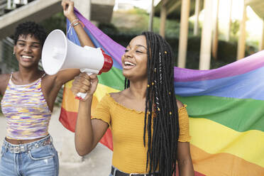 Happy lesbian woman speaking through megaphone - JCCMF03943