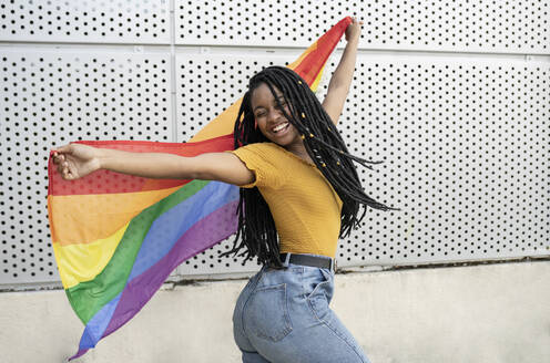 Unbeschwerte lesbische Frau tanzt mit Pride-Flagge - JCCMF03951