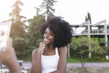 Eine Freundin fotografiert eine Afro-Frau mit ihrem Mobiltelefon - JCCMF03975