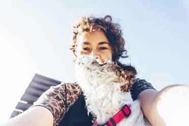 Mittlere erwachsene Frau macht Selfie mit Hund - OMIF00090
