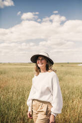 Glückliche Frau mit Hut auf einem landwirtschaftlichen Feld - GRCF00913