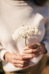 Frau hält weiße Blume - GRCF00923