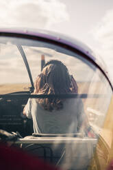 Blond woman wearing headphones in propeller airplane - GRCF00931