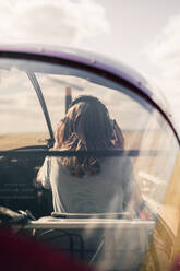 Blonde Frau mit Kopfhörern im Propellerflugzeug - GRCF00931