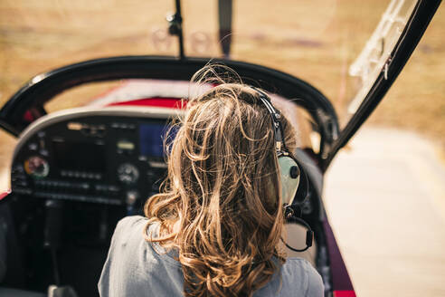 Reife Frau mit blondem Haar sitzt im Flugzeug - GRCF00932