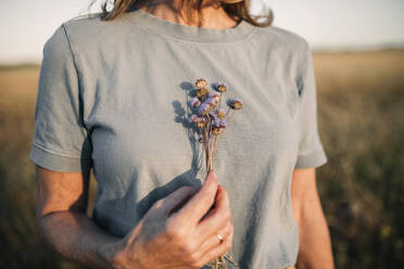 Woman holding bunch on flowers - GRCF00977