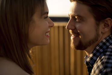 Couple looking at each other during sunset - LLUF00118