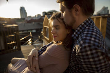 Girlfriend with eyes closed leaning on boyfriend at rooftop - LLUF00121