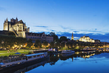 France, Yonne Department, Auxerre, Bank of Yonne river at dusk with treelined promenade and Auxerre Cathedral in background - GWF07181